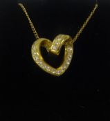 An 18ct yellow gold diamond set heart pendant on fine chain.