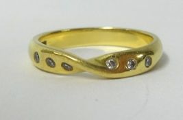 An 18ct gold wedding band set with small diamonds, approx 4gms.