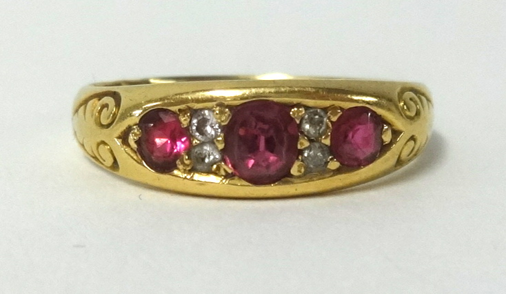 An antique 18ct gold ruby and diamond ring, set with three ruby's and four old cut diamonds,