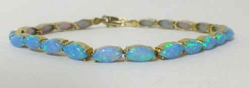 A 14ct opal line bracelet set in yellow gold.