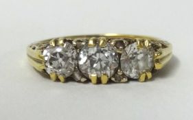 An Edwardian 3 stone diamond set ring, set with old cut diamonds in unhallmarked yellow gold, finger