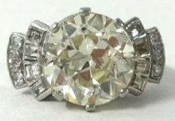 An impressive diamond solitaire ring, approx 4.02cts, further baguette and round cut diamonds to the