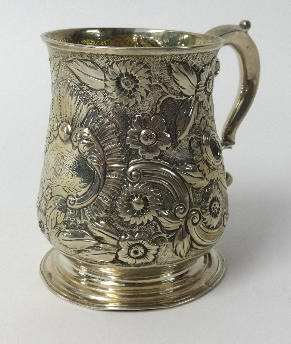 A Georgian silver christening mug richly embossed with decoration of flowers etc, approx 7.24ozs,