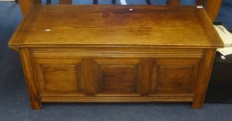 An oak blanket chest with fielded panels.