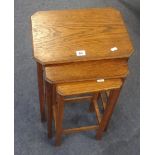 An oak nest of three tables and a circular low coffee table.