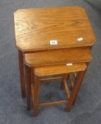 An oak nest of three tables and a circular low coffee table.