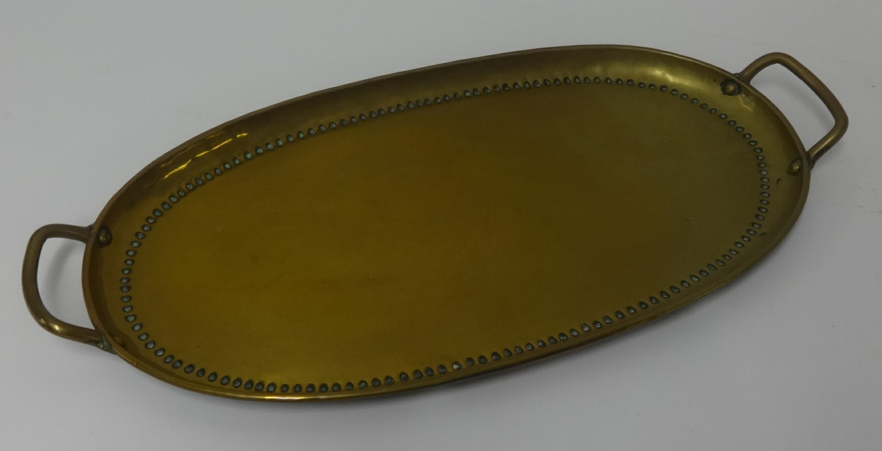 An unusual large pierced Indian copper wall plaque and a brass handled tray (2).