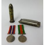 A pair of WWII medals awarded to H.E.Mitchell, Kingsbridge, boxed, also an harmonica and 'trench