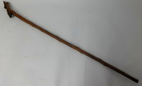 An unusual carved wood walking stick with stylised dragon detail, 114cm long.