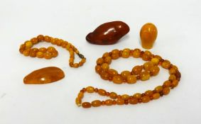 Amber, a bead necklace and bracelet and three carved amber stones, gross weight 103gms.
