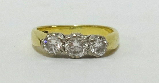 An 18ct three stone diamond ring comprising centre around brilliant cut diamond approx 0.50cts,