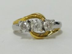 A three stone diamond ring set in white and yellow gold, finger size P.