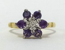 An 18ct amethyst set and diamond cluster ring, finger size P.