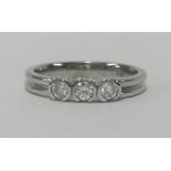 An 18ct white gold and three stone diamond ring, finger size N.