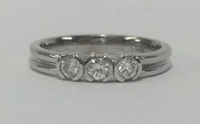 An 18ct white gold and three stone diamond ring, finger size N.
