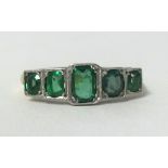 An antique 18ct gold and platinum five stone emerald ring, finger size O.