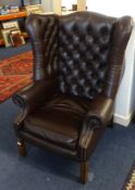 A leather upholstered heavy wing arm chair of Georgian design.