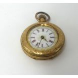 An antique 14ct gold fob watch, with enamel and gilt dial and roman numerals in red.