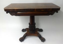 An early Victorian rosewood fold over card table, the pedestal base with carved acanthus leaf column