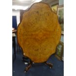 A Victorian figured walnut breakfast table on carved walnut base (historic woodworm to the base).