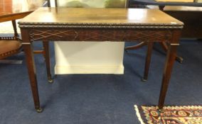 A Georgian mahogany fold over tea table with blind fretwork carving.