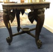 A carved hardwood Indian centre table, the legs carved as stylised elephants.