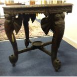 A carved hardwood Indian centre table, the legs carved as stylised elephants.