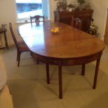 A Georgian mahogany dining table, comprising a pair of half round ends, with two old replacement