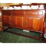 OAK SIDEBOARD WITH THREE DRAWERS ABOVE THREE CUPBOARD DOORS STANDING ON STRETCHERED LEGS