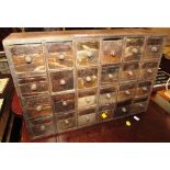 SMALL PRIMITIVE WOODEN TABLE TOP BANK OF TWENTY FOUR DRAWERS (A/F)