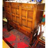 OAK THREE DOOR AND TWO DRAWER SIDEBOARD STANDING ON STRETCHERED LEGS