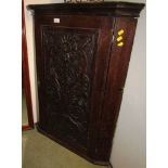 OAK WALL MOUNTED CORNER CUPBOARD WITH HEAVILY CARVED PANEL