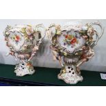 PAIR OF CONTINENTAL PORCELAIN URN SHAPED VASES ENCRUSTED WITH FLOWERS AND MOULDED WITH CHERUBS, WITH