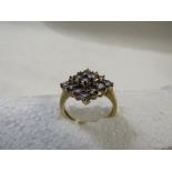9ct gold ring with a lozenge shape claw setting of sixteen pale blue stones, British assay marks,