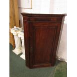 A 19th century mahogany corner cupboard with dentil cornice, a plain geometrically moulded door,