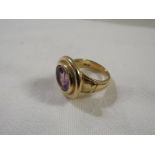 Gold ring set with an amethyst (11mm x 9mm approx) in a broad oval bezel setting, commissioned of