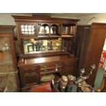 A mahogany Arts and Crafts style sideboard, the top section with mirrored back panels and cupboard