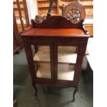 An Edwardian mahogany china cabinet with two glazed doors with paper lined interior and single