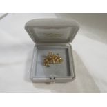 18ct gold floral spray brooch set with four small emeralds and twenty-one diamonds, 3.1cm x 2cm