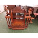 An oak hall seat and twin umbrella stand, the central seat with hinged lid, the whole with foliate