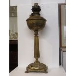 Brass oil lamp with embossed reservoir on a reeded tapering column with circular foot pierced and