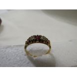 18ct gold ring set in a row with two diamonds (estimated at 0.2 carat each) with a central ruby