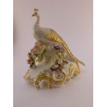 Royal Crown Derby model of a peacock seated on a bough with four branches of encrusted flowers, on a