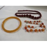 A necklace of amber and glass beads (length 43cm), a necklace of plastic beads resembling amber, and