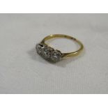 Gold ring with a row of three brilliant cut diamonds in a platinum setting, the largest central