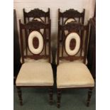 A set of four early 20th century red walnut framed dining chairs, the carved backs with oval ring of