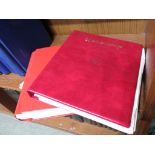 A red ring binder containing loose leaf of foreign stamps, and a red stamp album containing a