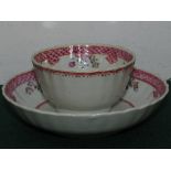 A New Hall style porcelain tea bowl and saucer, mauve and pink sprays with margins of puce scales;