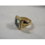 Gold ring set with a blue stone (perhaps blue topaz) (11mm x 11mm approx) in a broad square bezel