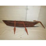 A small wooden model of a boat, length 73cm, with three oars